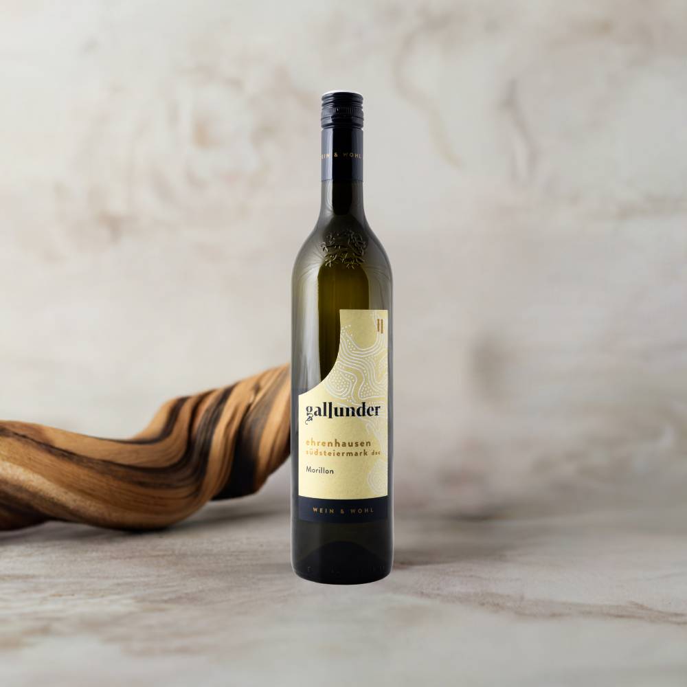 Morillon Weinflasche auf Mamorplatte mit Holzwurzel im Hintergrund.