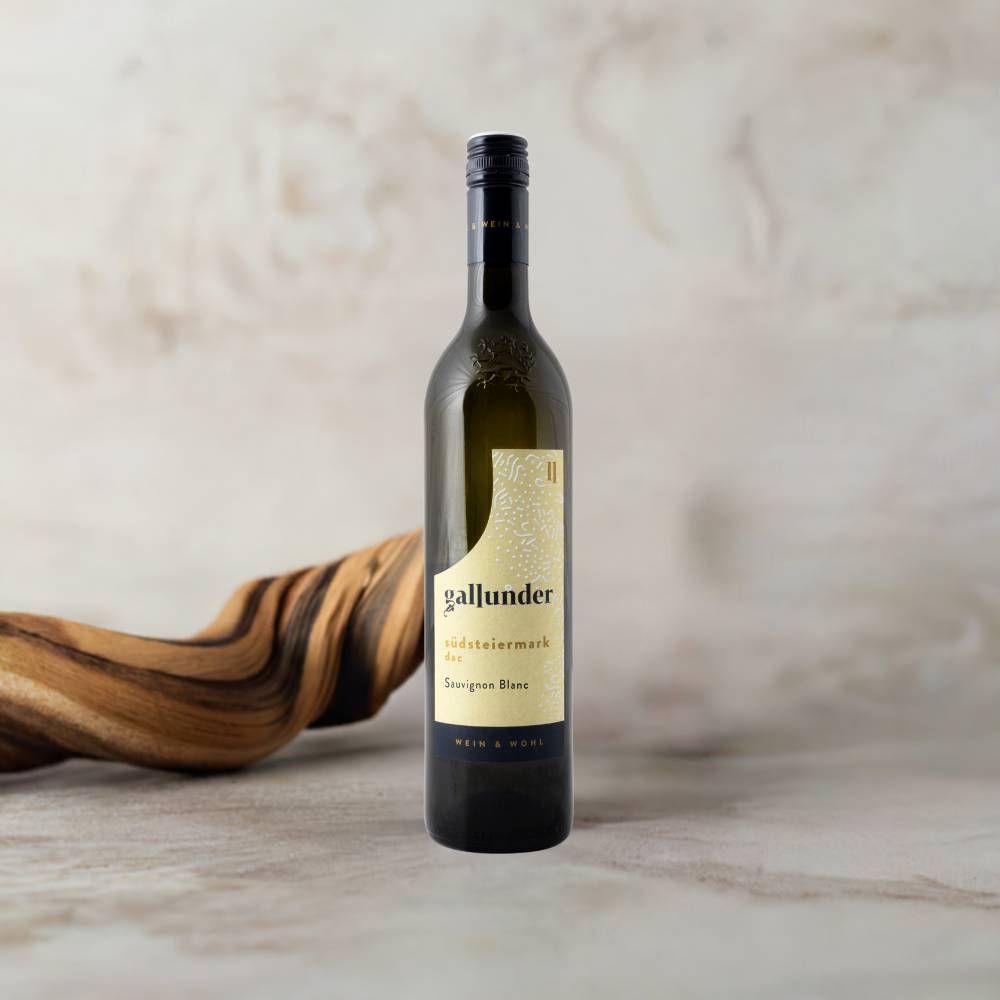 Sauvignon Blanc Weinflasche auf Mamorplatte mit Holzwurzel im Hintergrund.